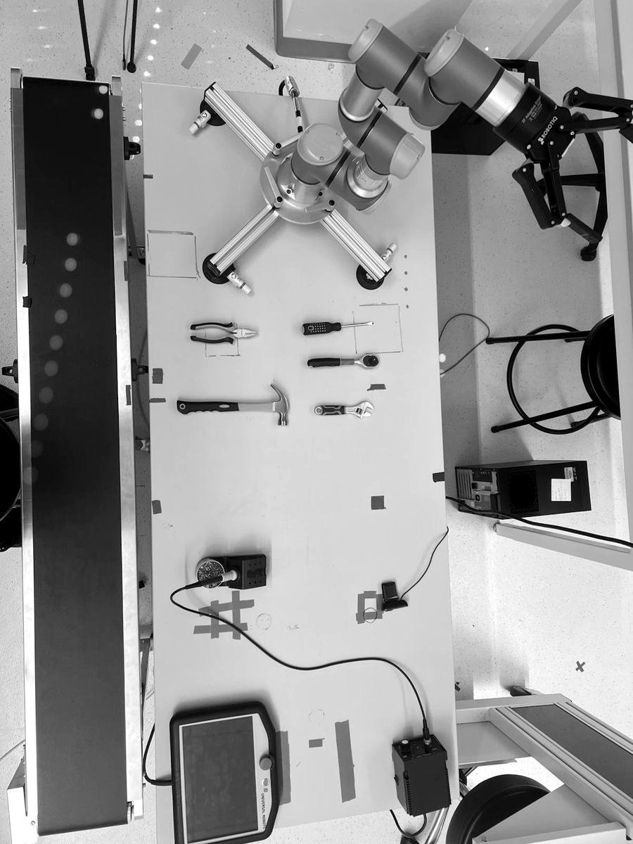 Overhead view of the robot arm, gripper and hand tools on the lab bench